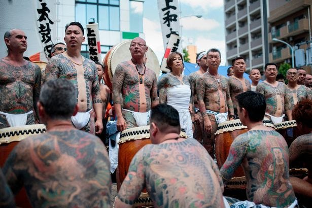 Participants pose to show their traditional Japanese tattoos (Irezumi), related to the Yakuza, during the annual Sanja Matsuri festival in the Asakusa district of Tokyo on May 20, 2018. - Sanja Matsuri festival is a celebration for the three founders of Sensoji Temple in the Asakusa neighbourhood with nearly two million people visiting during the three-day event. (Photo by Behrouz MEHRI / AFP) (Photo credit should read BEHROUZ MEHRI/AFP via Getty Images)