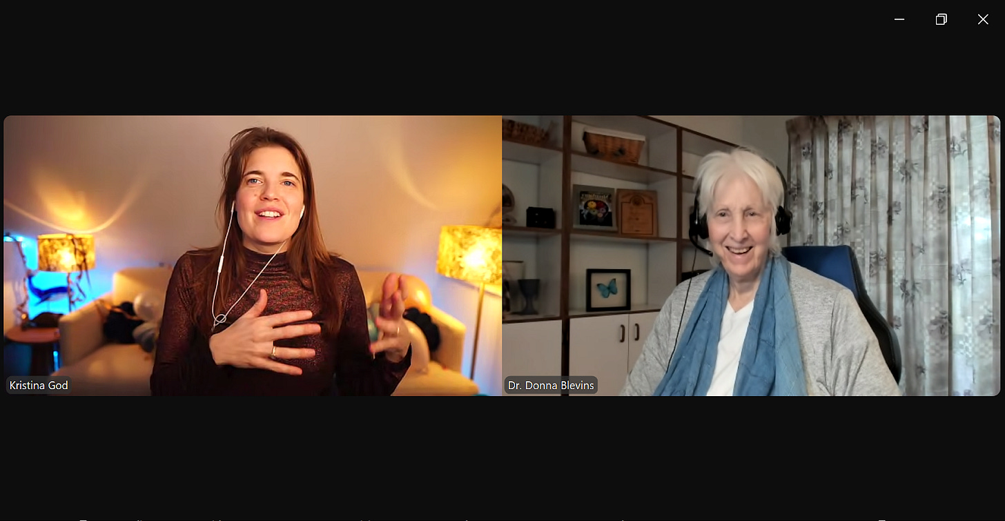 Zoom screenshot. On the left is Kristina God, a joyful, animated woman in brown clothing with a lighted background. On the right is Donna Blevins, smiling in grey clothing with a blue scarf in front of a bookshelf and floral curtains.