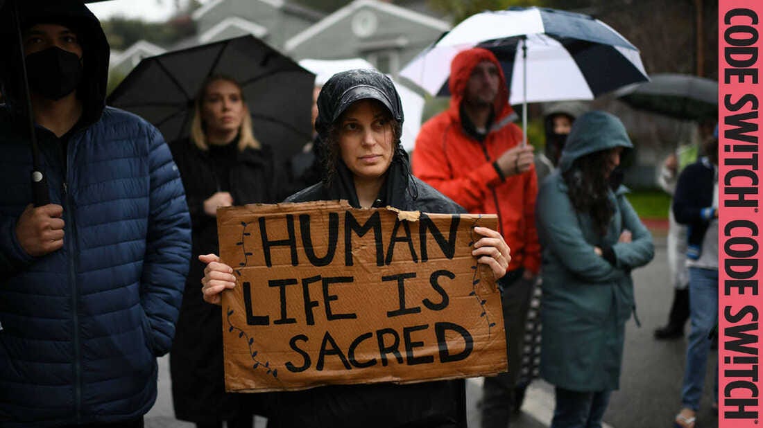 A woman stands in the rain at a Jewish mourning ceremony for the Palestinians and Israelis killed since October 7 and to protest Israeli government actions in Gaza.