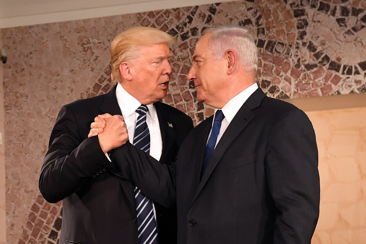 Trump clasping hands with Netanyahu in 2017
