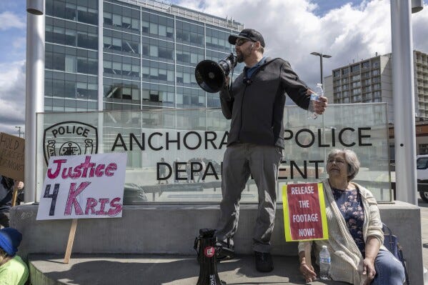 Travis Handy, brother of Kristopher Handy who was killed by Anchorage police on May 13, 2024, talks to other marchers outside police headquarters in downtown Anchorage, Alaska, on May 25, 2024, when they called for police to release footage from officers' body cameras. Only months after Anchorage police officers began wearing body cameras, three police-involved shootings in three weeks have rattled residents and created a fight over transparency. (Marc Lester/Anchorage Daily News via AP)