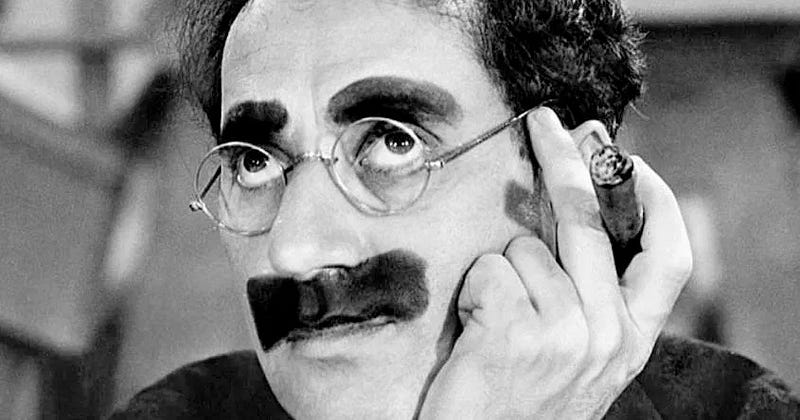 Grayscale picture of Groucho Marx rolling his eyes — he has big circular glasses, a goofy moustache, and a cigar