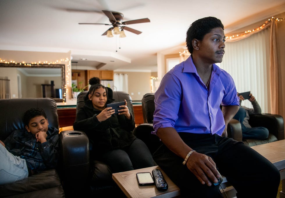 Kendrick Harrison pores over dozens of email exchanges with Argosy University, a for-profit college that closed without warning. Kendrick's children, Alex, left, and Sierra, are seated behind him.