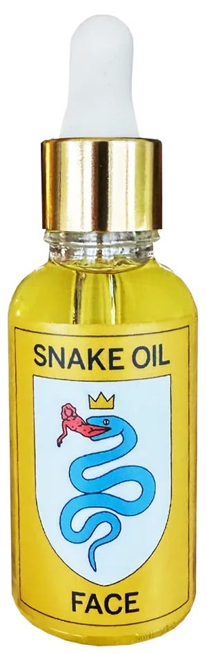 a small bottle of golden face oil with a sticker of a snake and 'snake oil' on the outside. 
