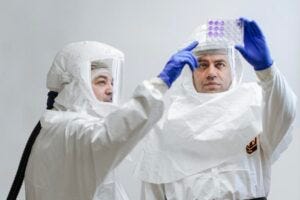 Professor Luis Martinez-Sobrido, Ph.D., (left) and Staff Scientist Ahmed Mostafa Elsayed, Ph.D., (right) review test results for the presence of bird flu while wearing protective equipment required for biosafety level-3 laboratories.