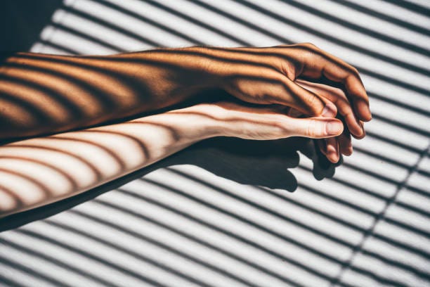 interracial couple holding hands on the bed. - couple hands stock pictures, royalty-free photos & images