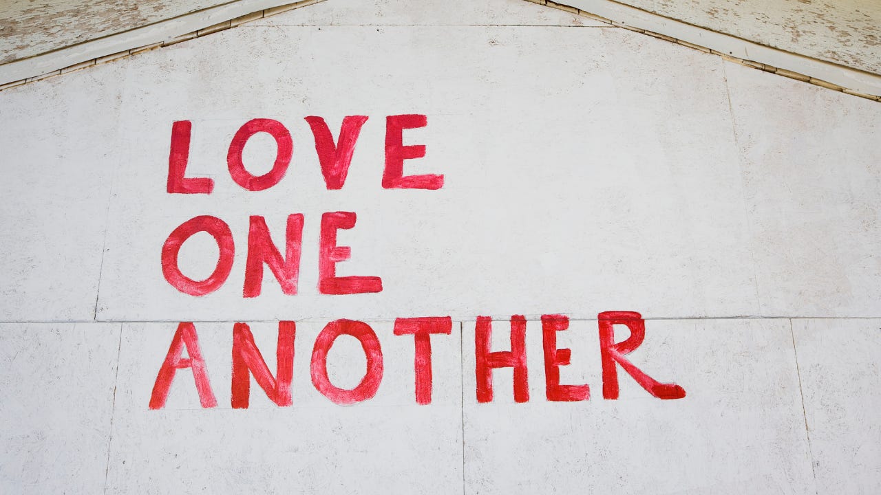 The words, "Love One Another" written in red.