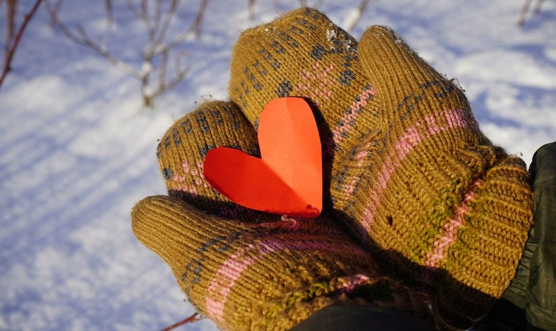 a glove with a heart on it in the snow