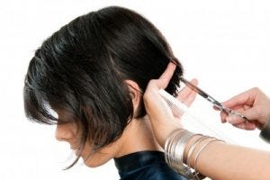 A young girl getting a hair cut.