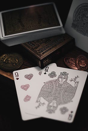 Image of a deck of cards and a 9 of hearts and queen of clubs.
