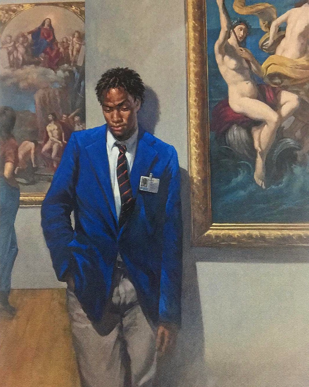 ArtGuard2000 by Dutch artist Deni Ponty. This is a painting showing a slim, tall young black man who is a museum worker, wearing a blue blazer, white shirt and dark tie with chinos. The man is gazing towards the floor and is flanked by seemingly canonical artworks filled with white figuration, suggestive that the normally overlooked museum worker is deserving of our contemplation instead of the fine art on display.