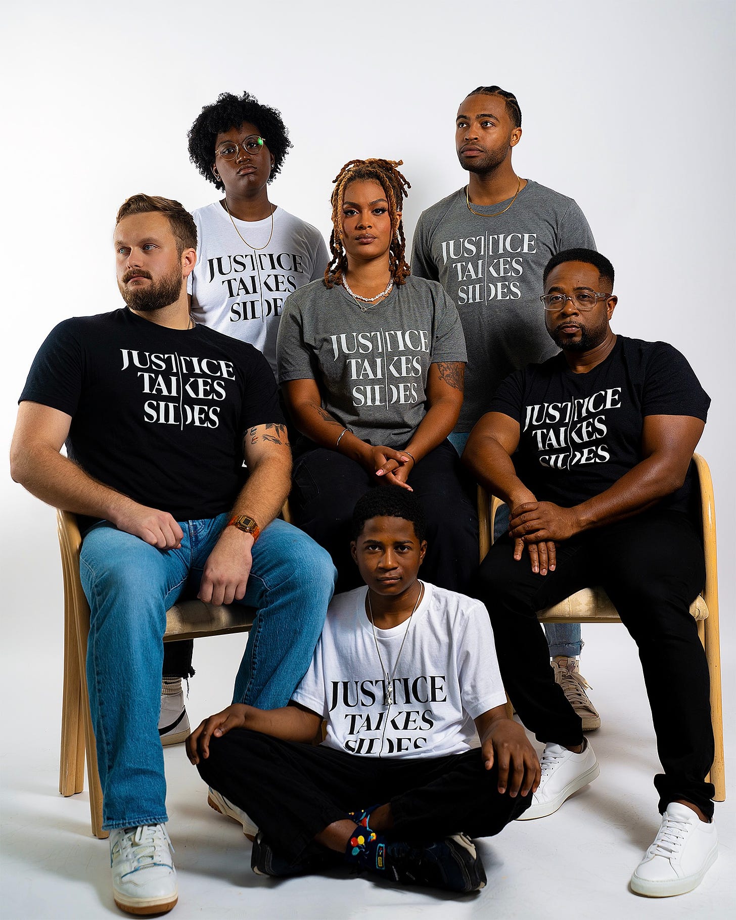 Six people standing and sitting in front of white background and wearing "Justice Takes Sides" t-shirts