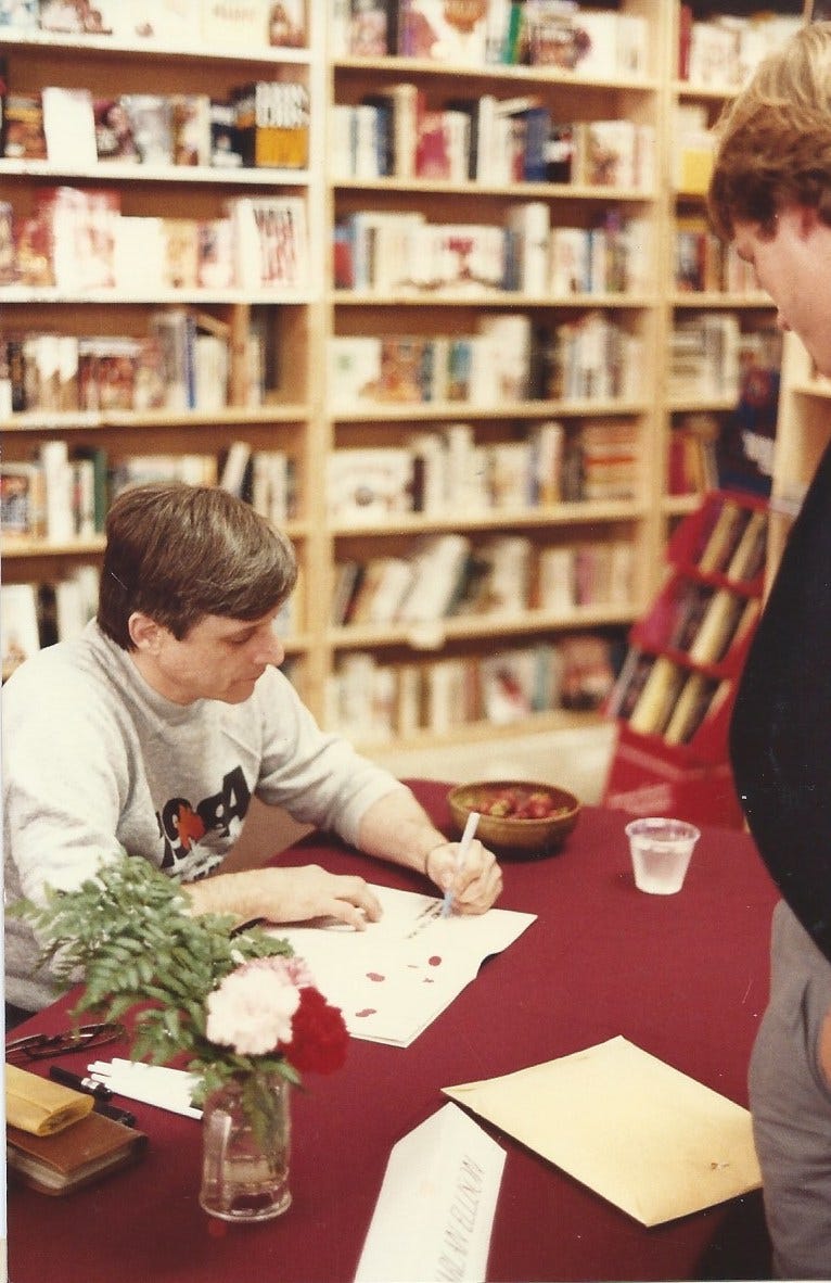Author Harlan Ellison at a bookstore appearance, signing a magazine article