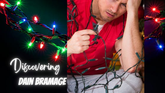 Blue, red and green Christmas lights shine brightly. A frustrated man sits tangled up in a strand of them, holding his head and looking in bafflement at all the dark bulbs.