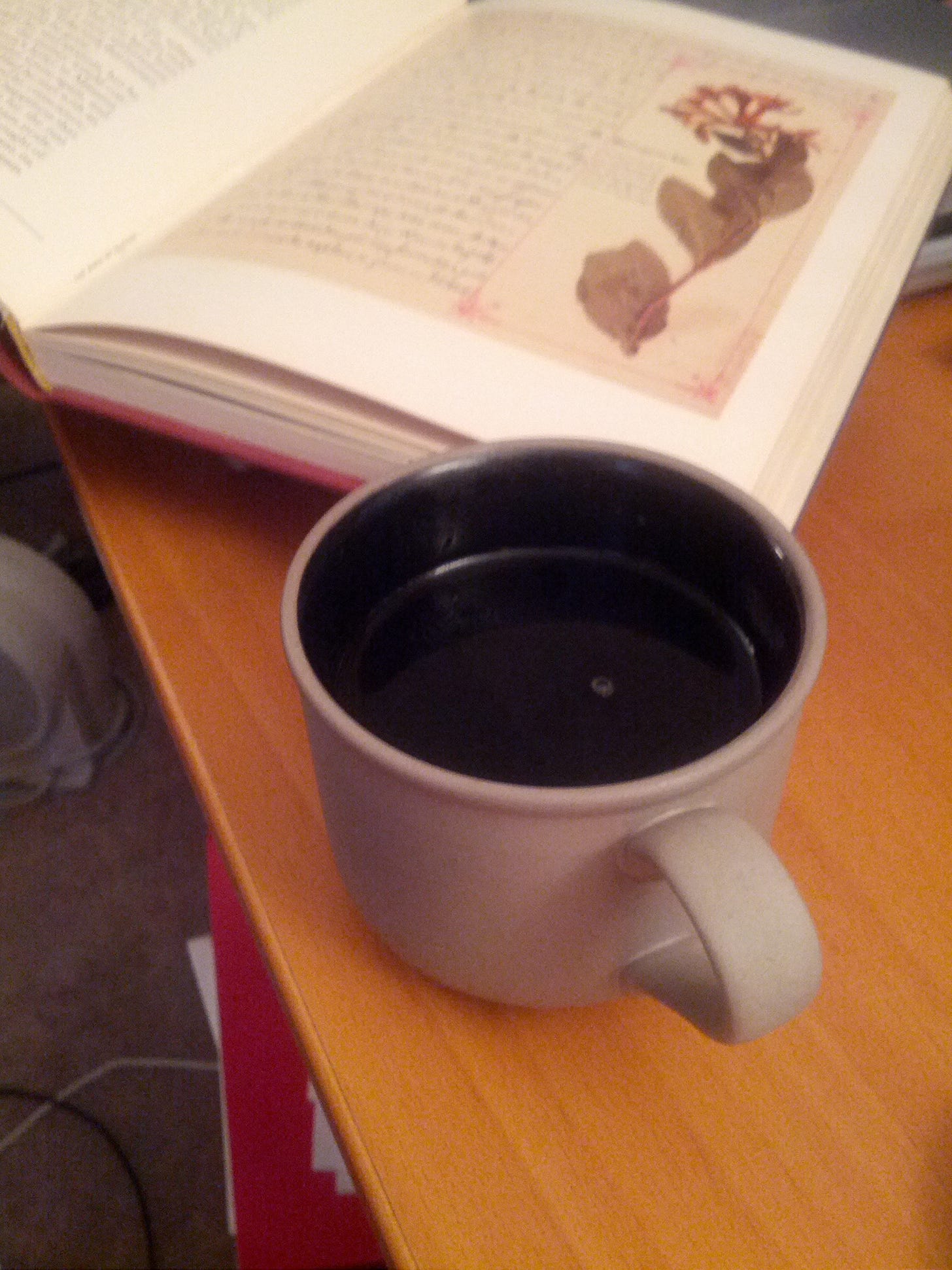 an open book and a mug of tea on a table