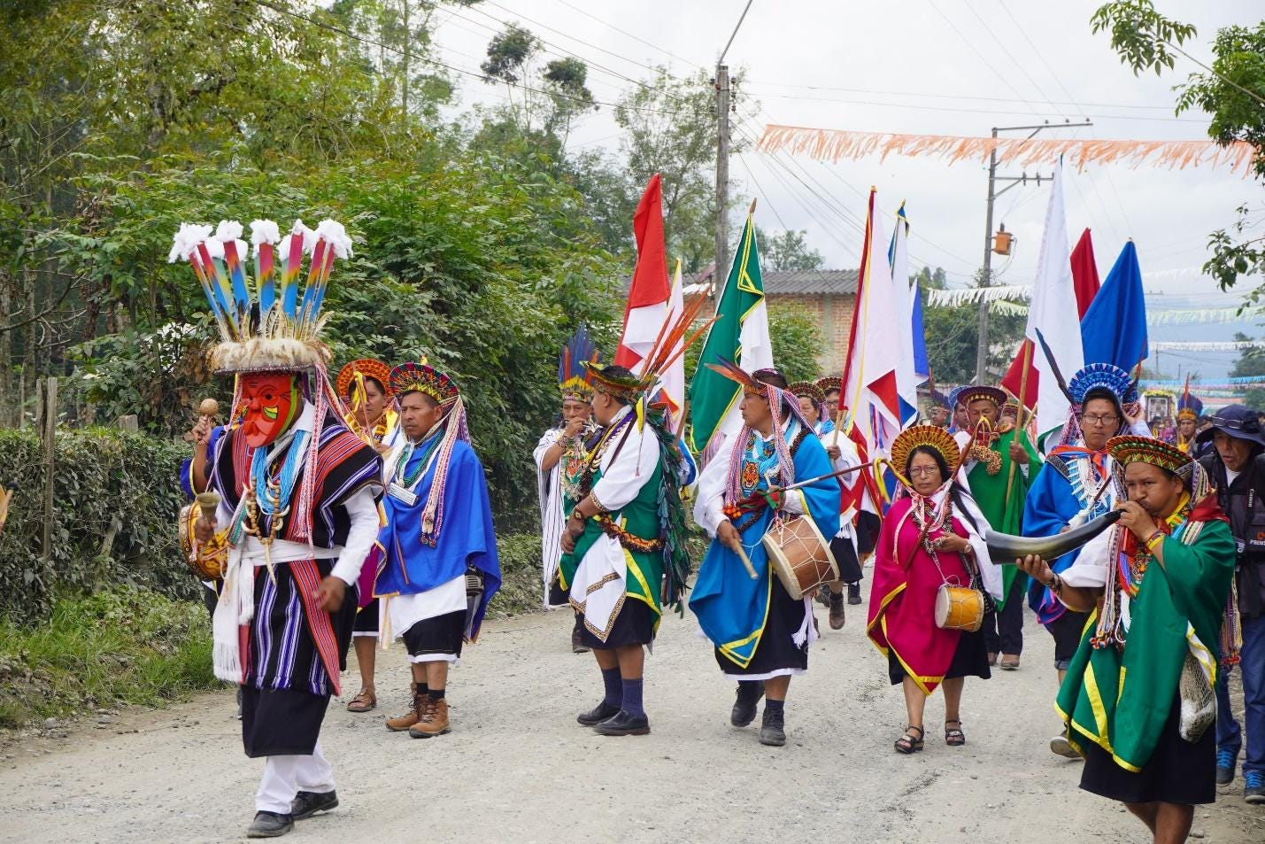 A group of people in traditional clothing walking down a road

Description automatically generated