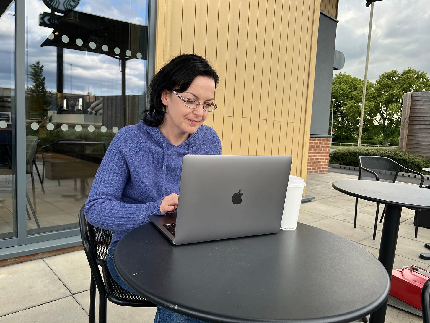 woman working on the mac book outside the Starbucks