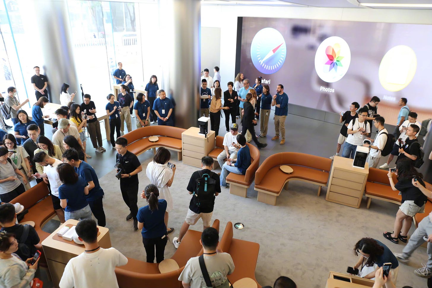 The Demo Zone at Apple Wangfujing. Two sets of sofas are placed in front of the video wall.