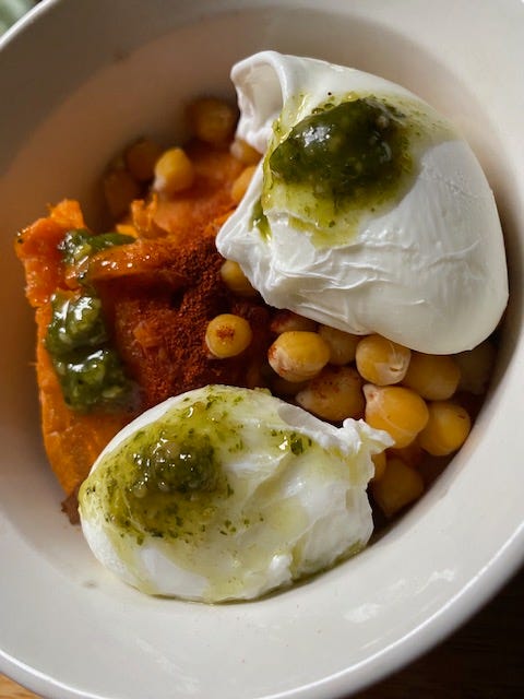 2 poached eggs over chickpeas and sweet potato with pesto drizzled on top