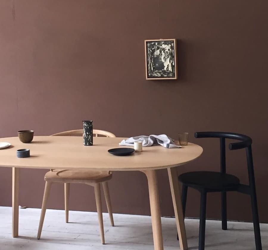 rich brown painted wall with wooden dining table and chairs