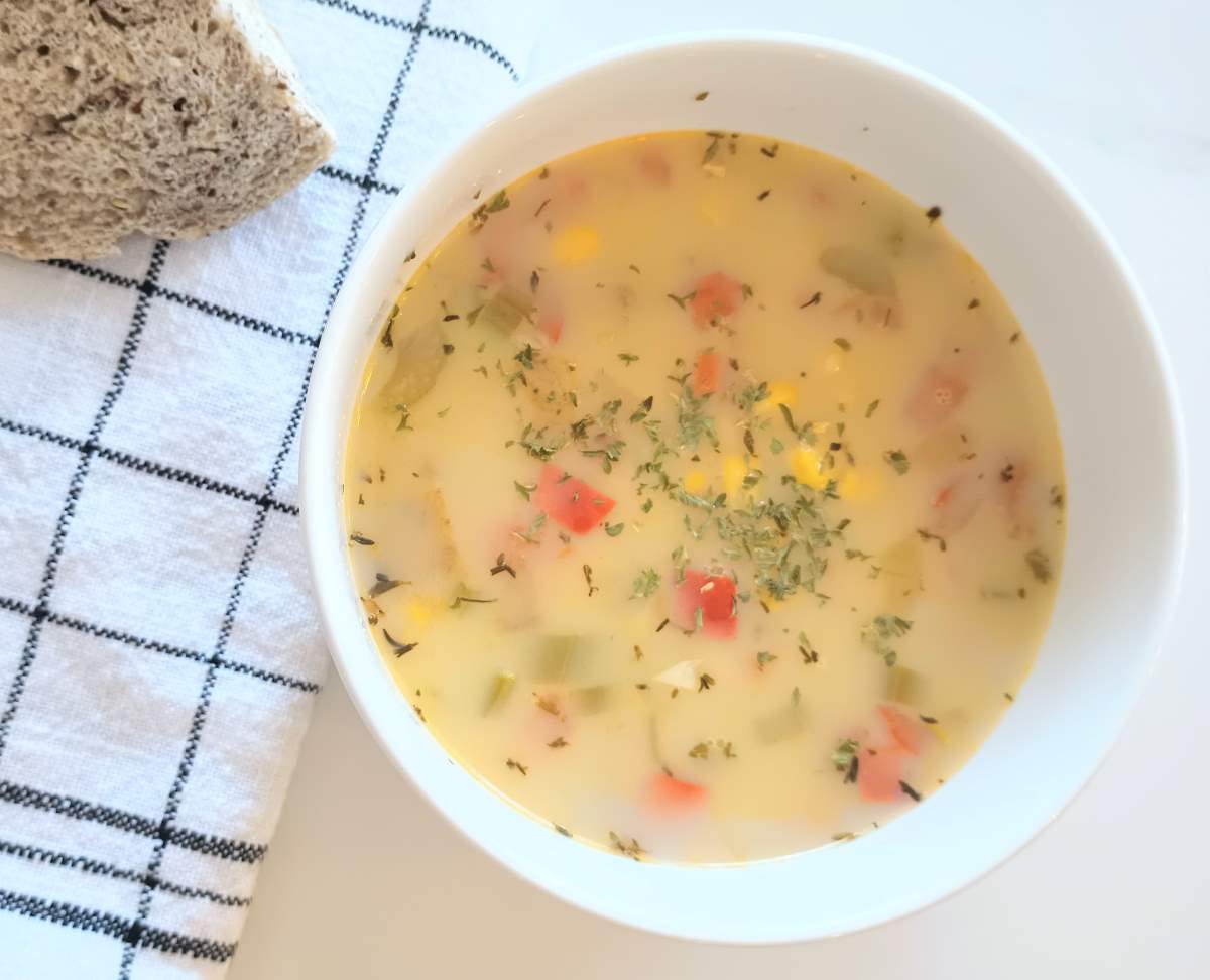 Easy Vegetable Corn Chowder in bowl with napkin and bread.