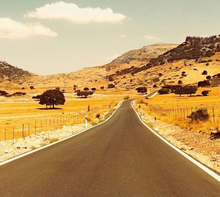 an empty road in the middle of the desert