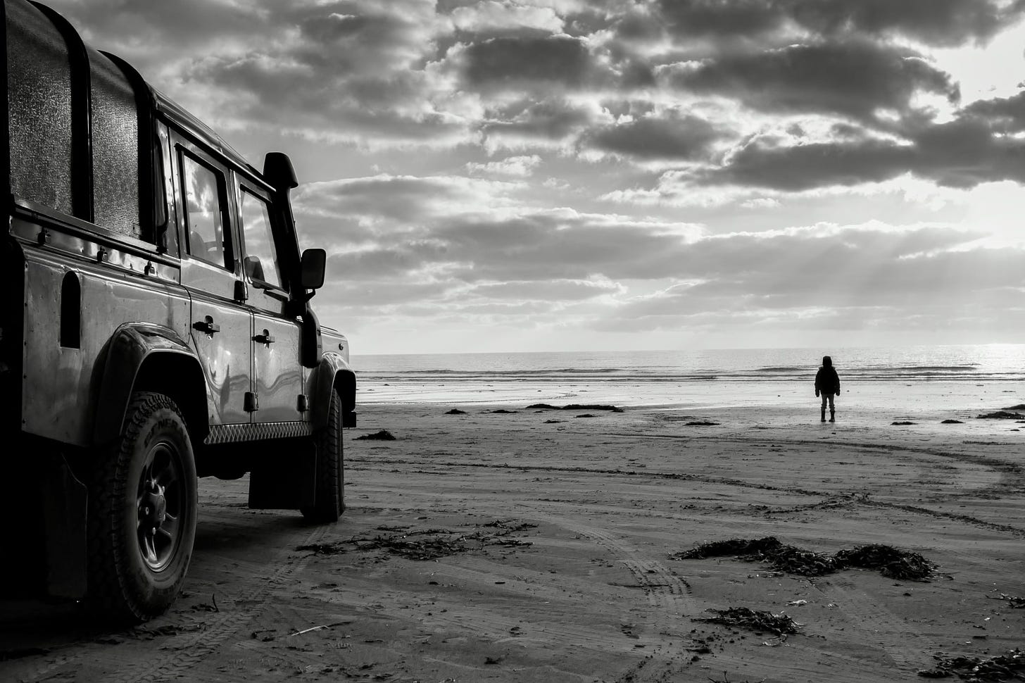 My old car and my not so old son standing on the beach