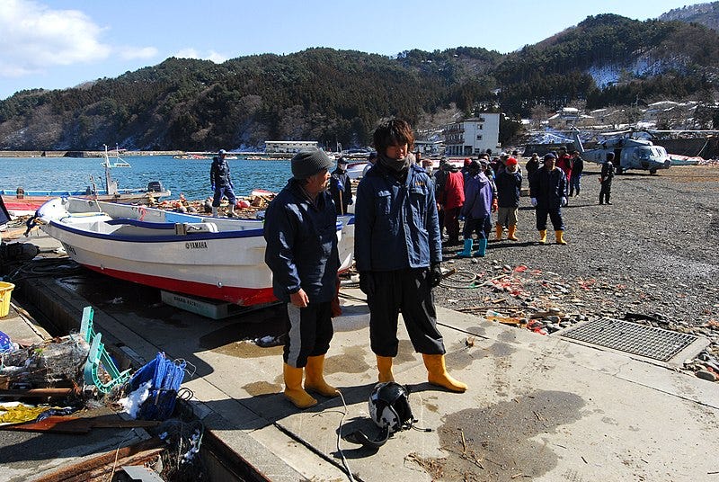 File:US Navy 110318-N-SB672-539 Japanese men stand near their boat in a fishing village affected by a 9.0-magnitude earthquake and subsequent tsunami.jpg