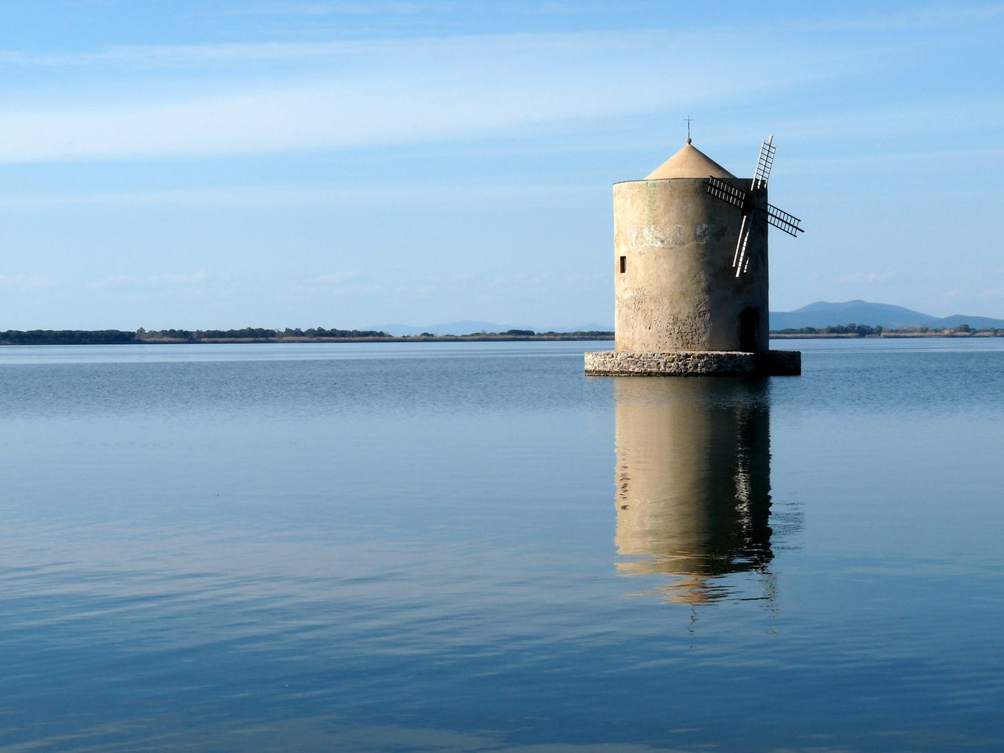 An ancient windmill set in the middle of a lagoon