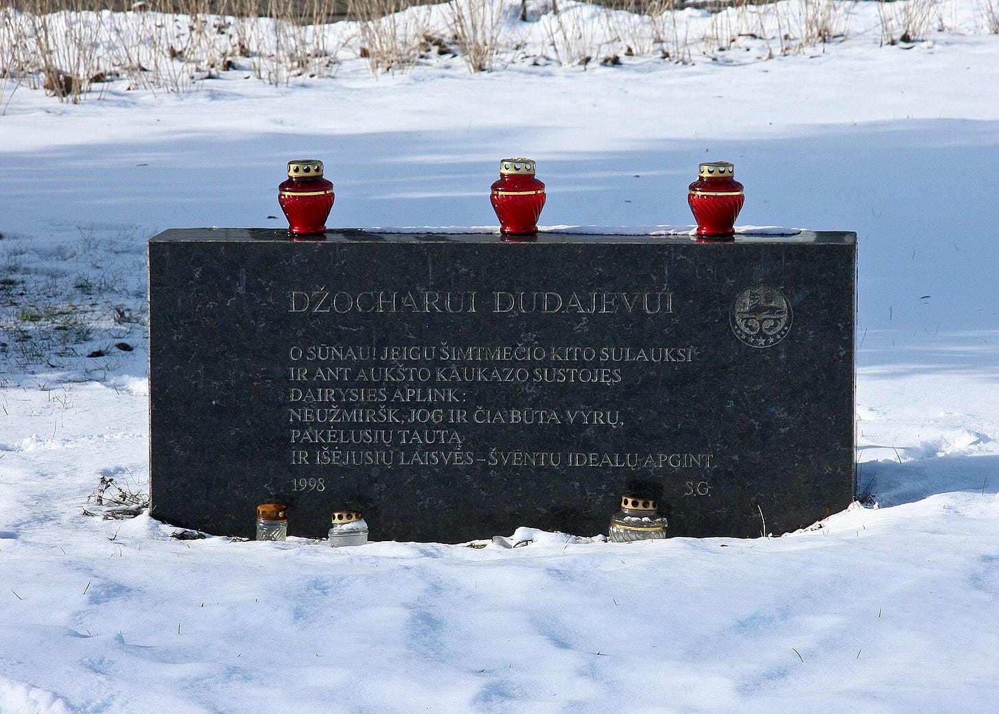 A grave stone with candles on it

Description automatically generated