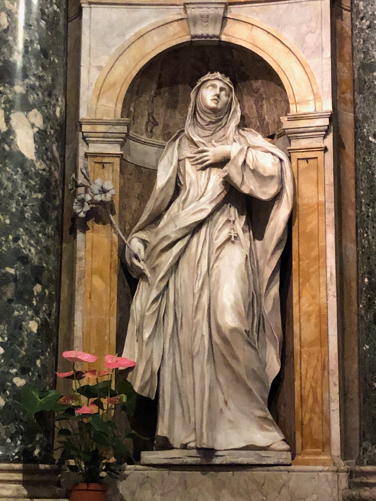 Statue of St. Catherine of Siena holding lily looking upward