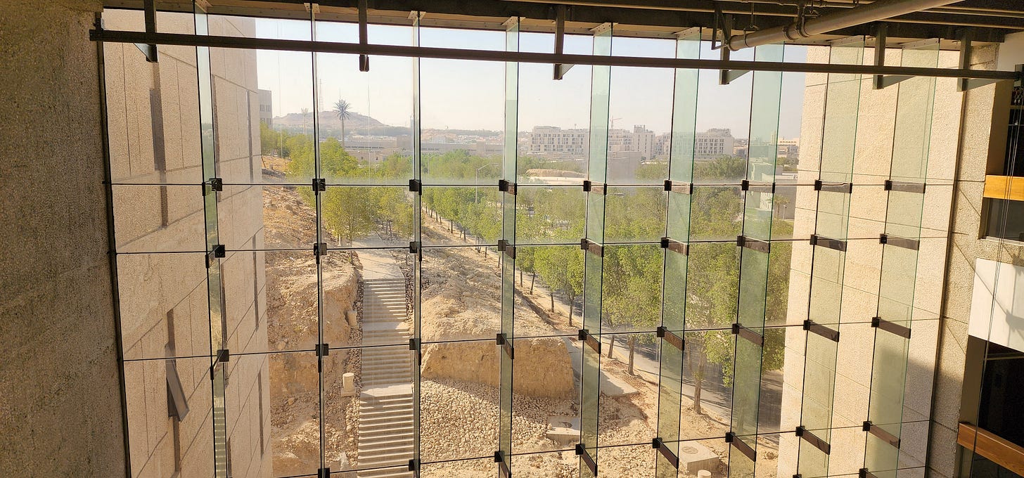 View from a window on the KFUPM campus -- looking out onto rugged desert with tall buildings in the background