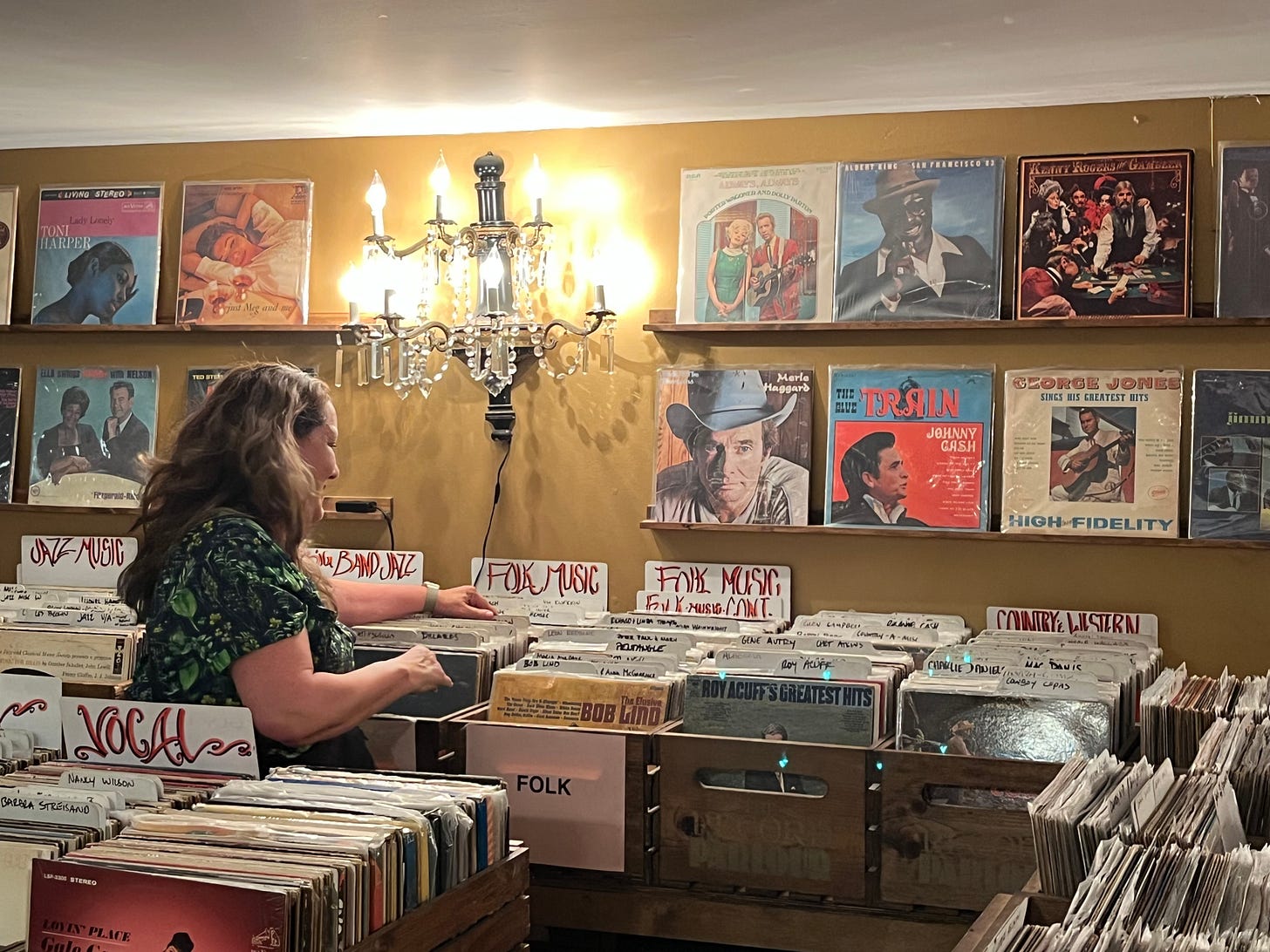 white woman in a record store smiling as she looks through the bins white woman in a record store smiling as she looks through the bins