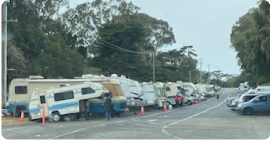 A group of rvs parked on a road

Description automatically generated