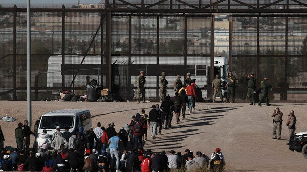 Migrants walk into U.S. custody after crossing the border from Mexico, Ciudad Juarez, Wednesday, March 29, 2023.