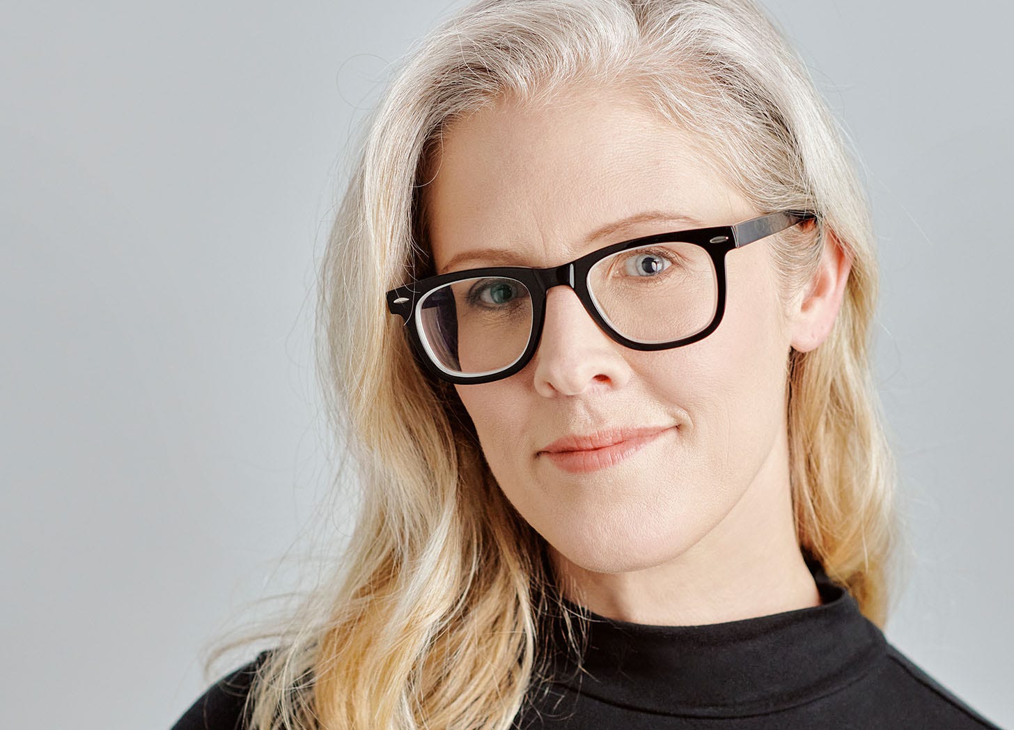 A headshot of NBC News journalist Brandy Zadrozny, who has long blonde hair and fantastic black-rimmed glasses