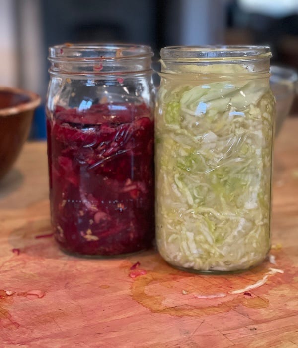 On the left a jar with beets, color is a deep pinkish purple. On the right a jar of shredded cabbage and fennel, looks like a regular jar of sauerkraut. 