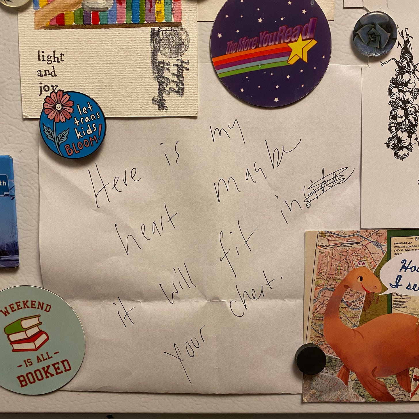 A handwritten page on my fridge, surrounded by colorful magnets. The quote reads: “Here is my heart, maybe it will fit in your chest.”