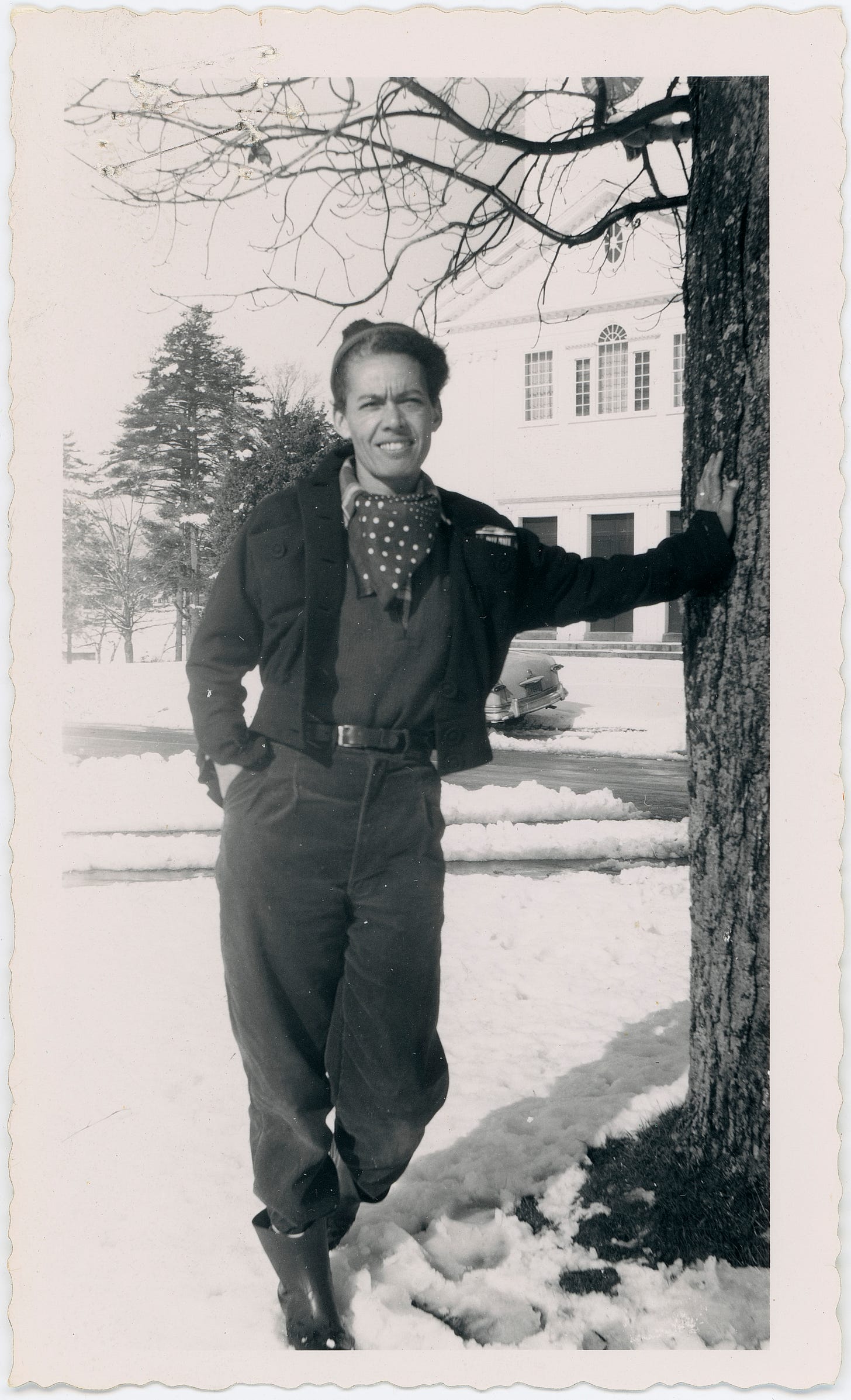 Pauli Murray wearing androgynous clothing standing next to a tree outdoors in winter 1955