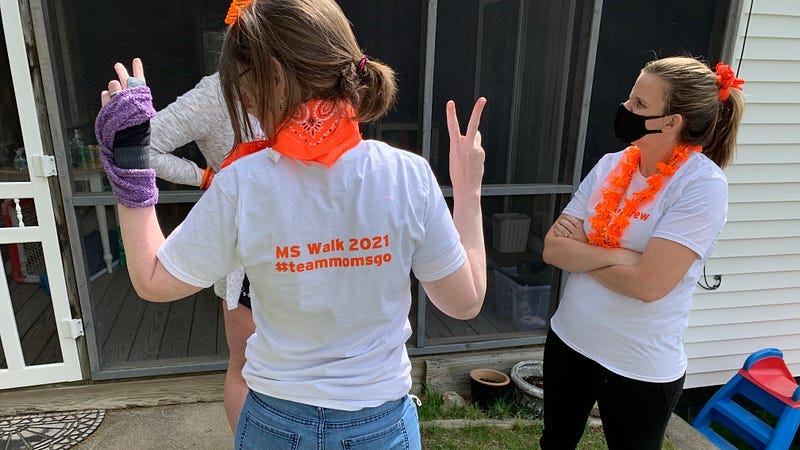 the author, a white woman with back to camera wearing a white and orange MS Support tshirt