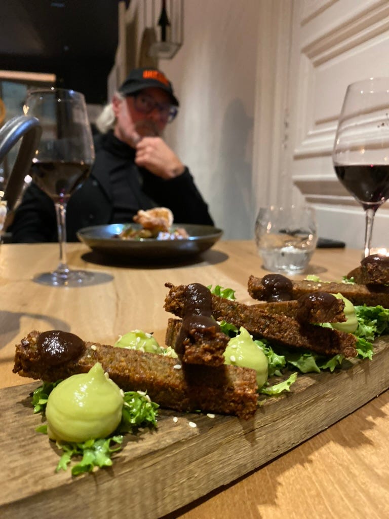 Food on a wood block with a man in the background