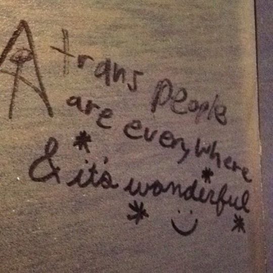 This may contain: graffiti written on the side of a toilet in a public restroom with writing underneath it