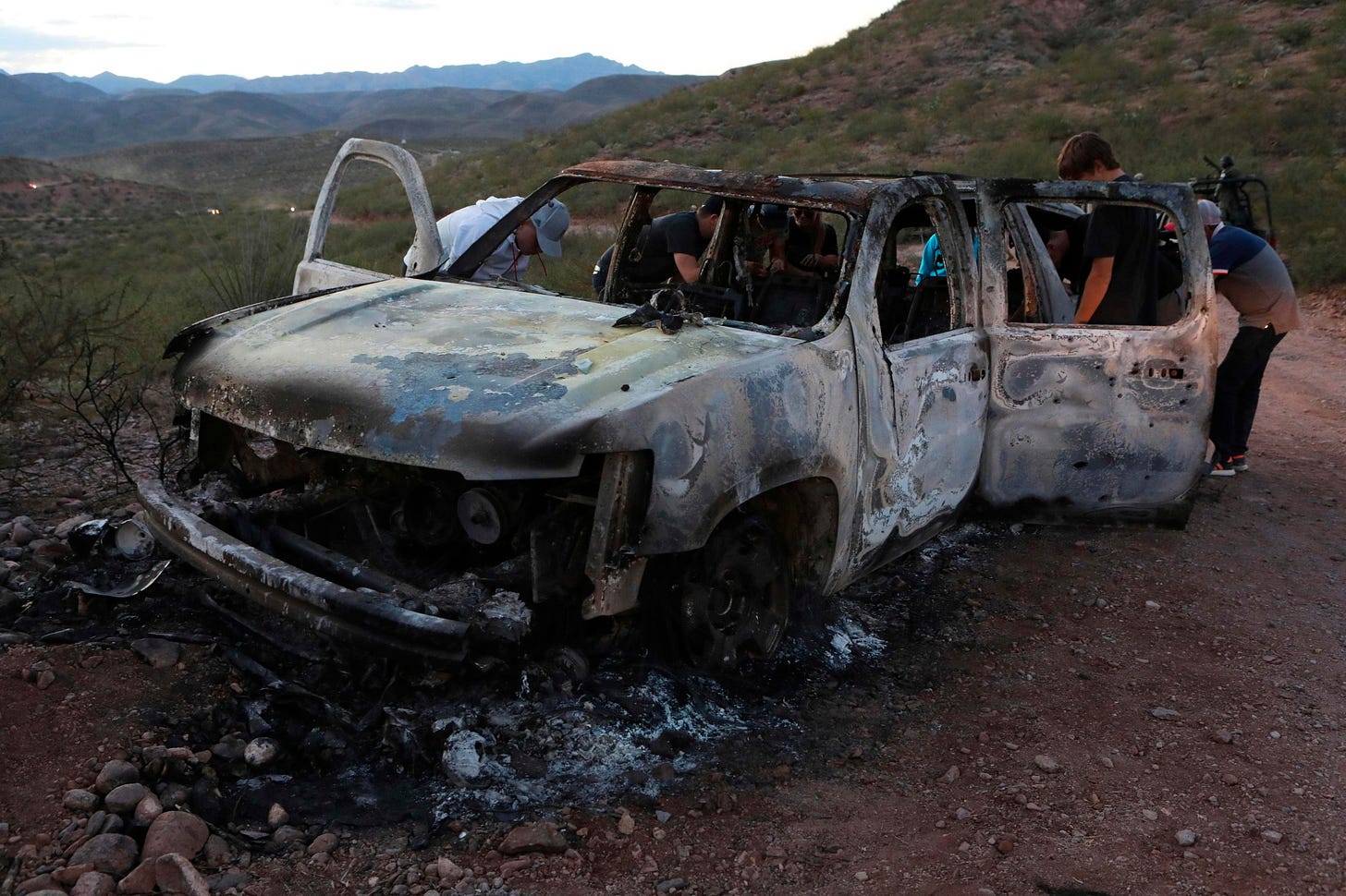 Members of the LeBaron family view the car where nine members of the family were killed Monday in Bavispe, Mexico. | AFP-JIJI