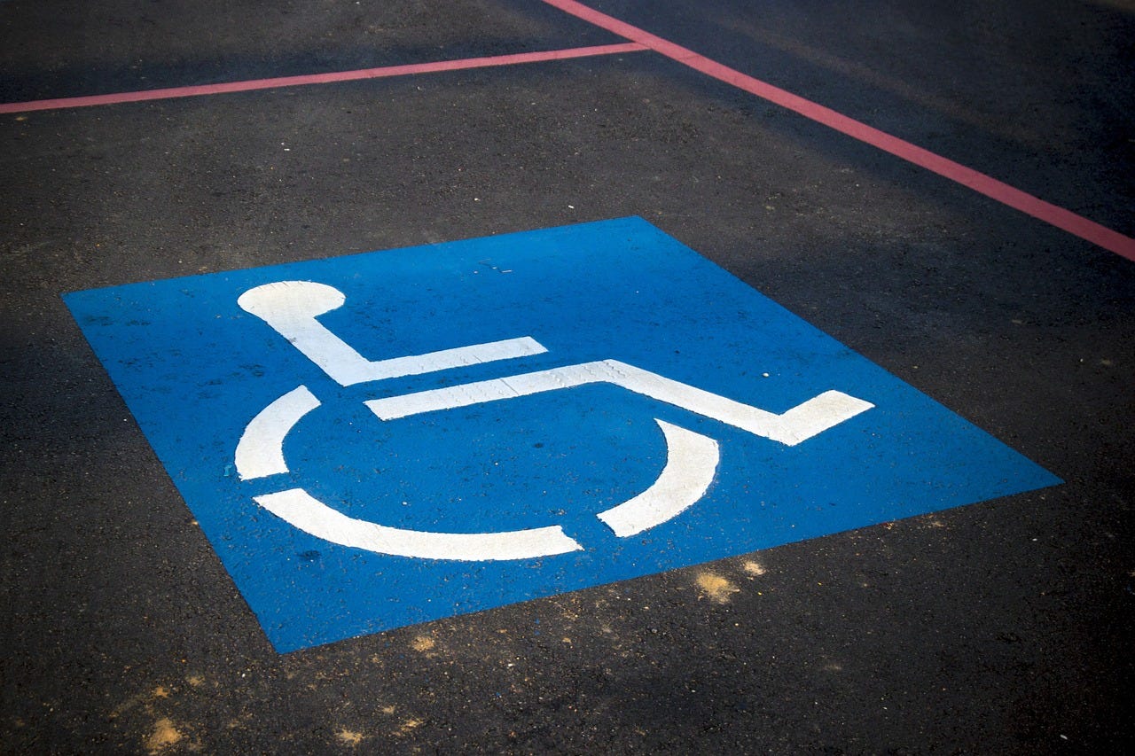 A handicap parking decal in a parking lot