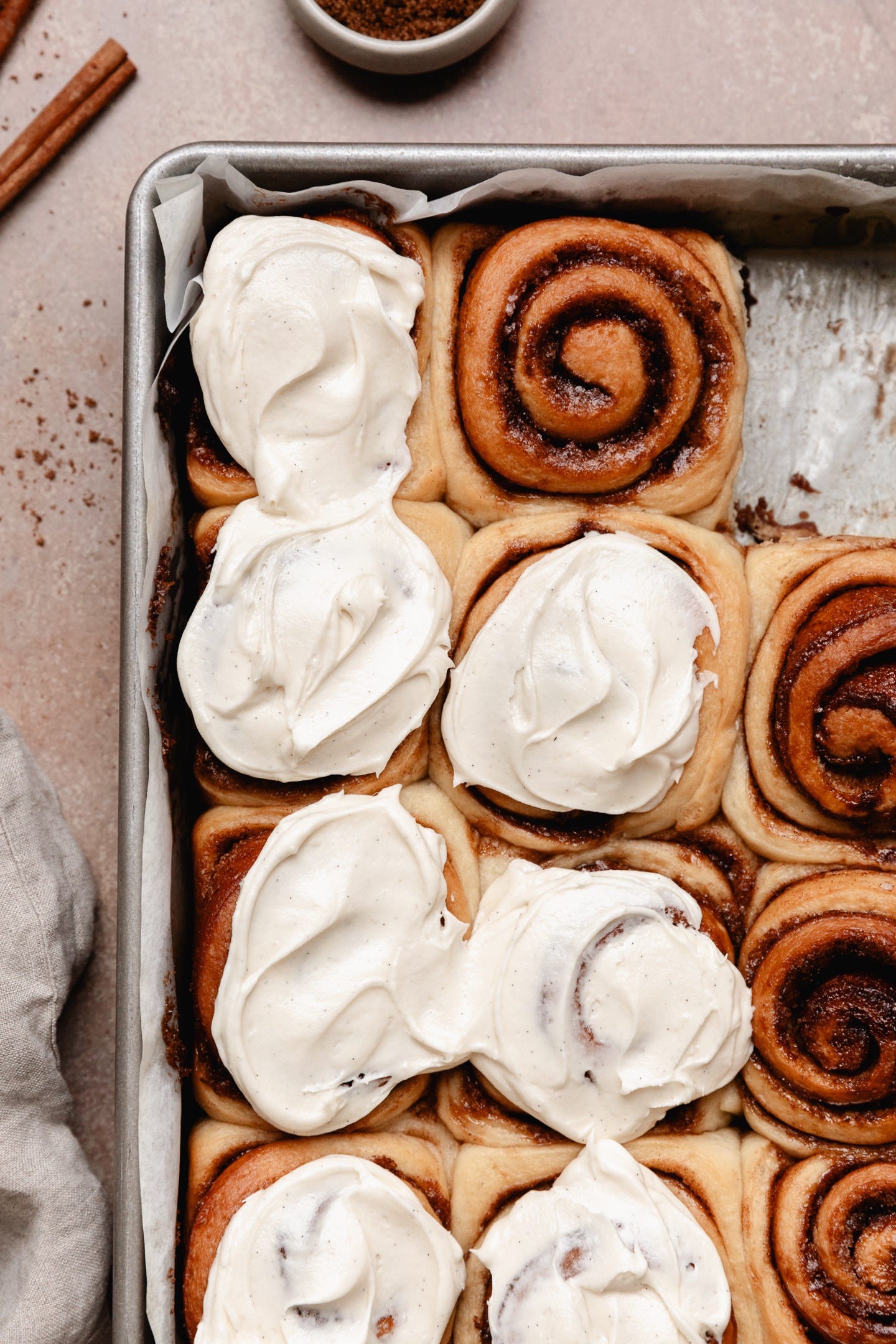 Close up shot of vegan cinnamon rolls topped with cream cheese frosting