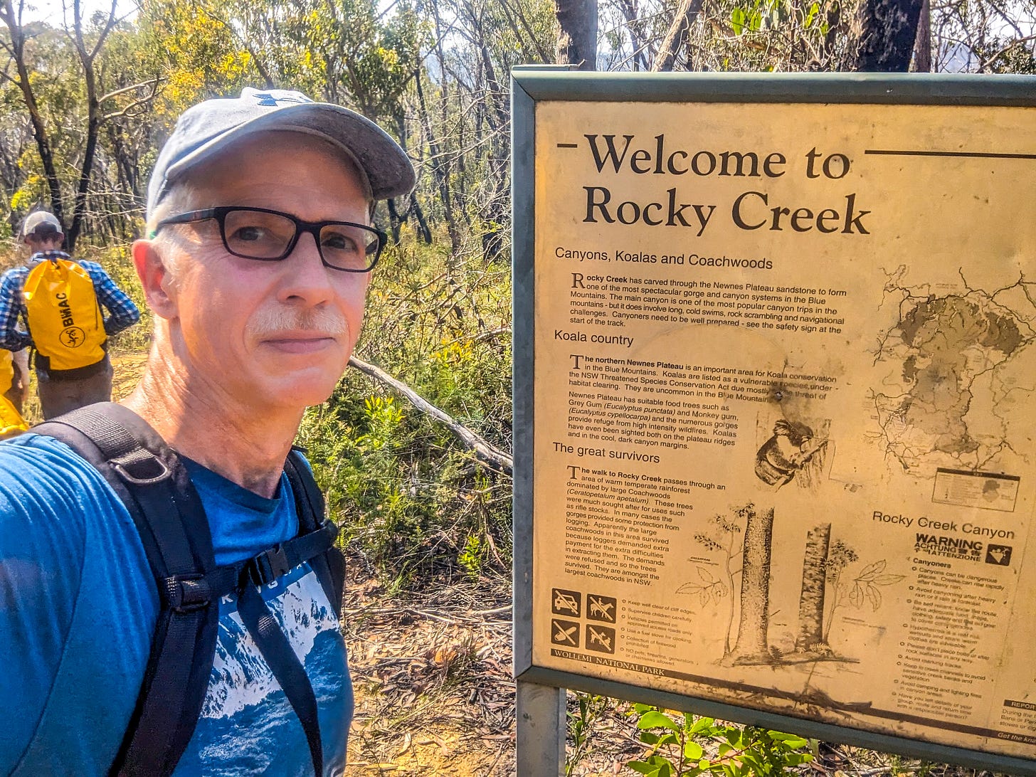 Michael standing in front of NPS sign reading Welcome to Rocky Creek.