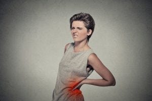 a thin woman grasping her left kidney in pain