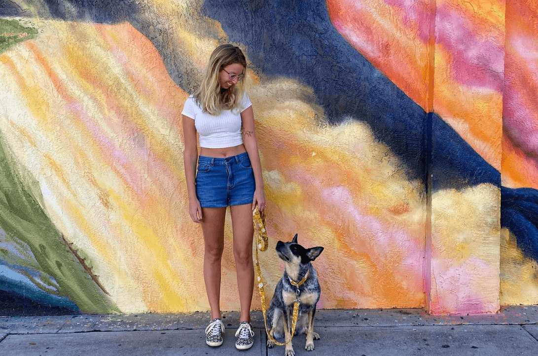 Haley the human and Scout the blue heeler pose in front of a mural