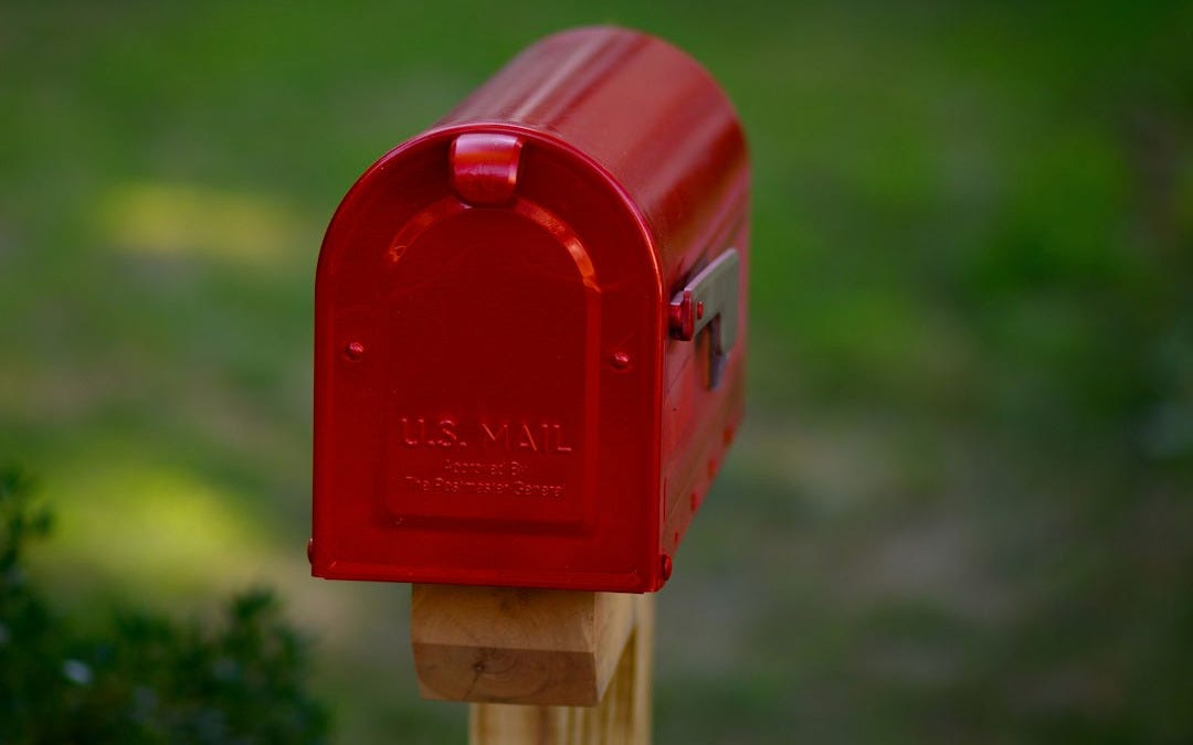 a red mailbox on a wooden post