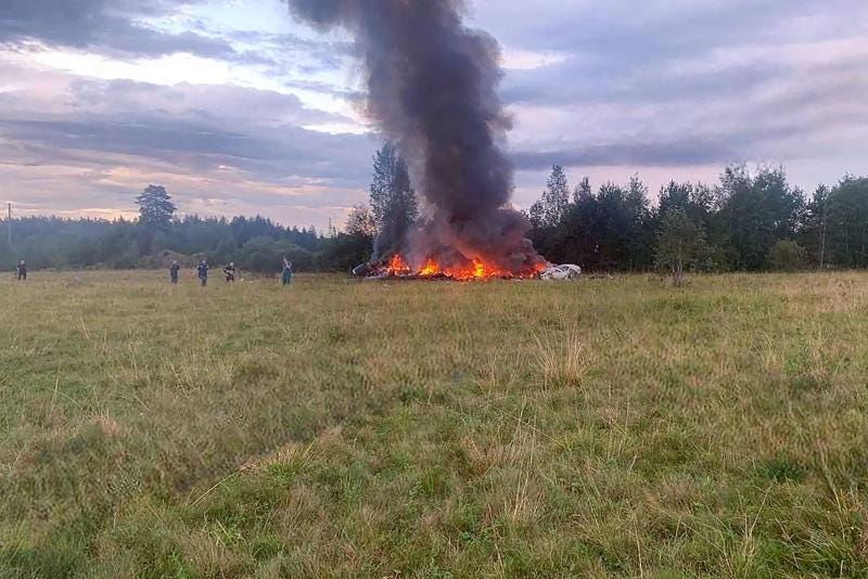 A group of people standing around a large fire

Description automatically generated